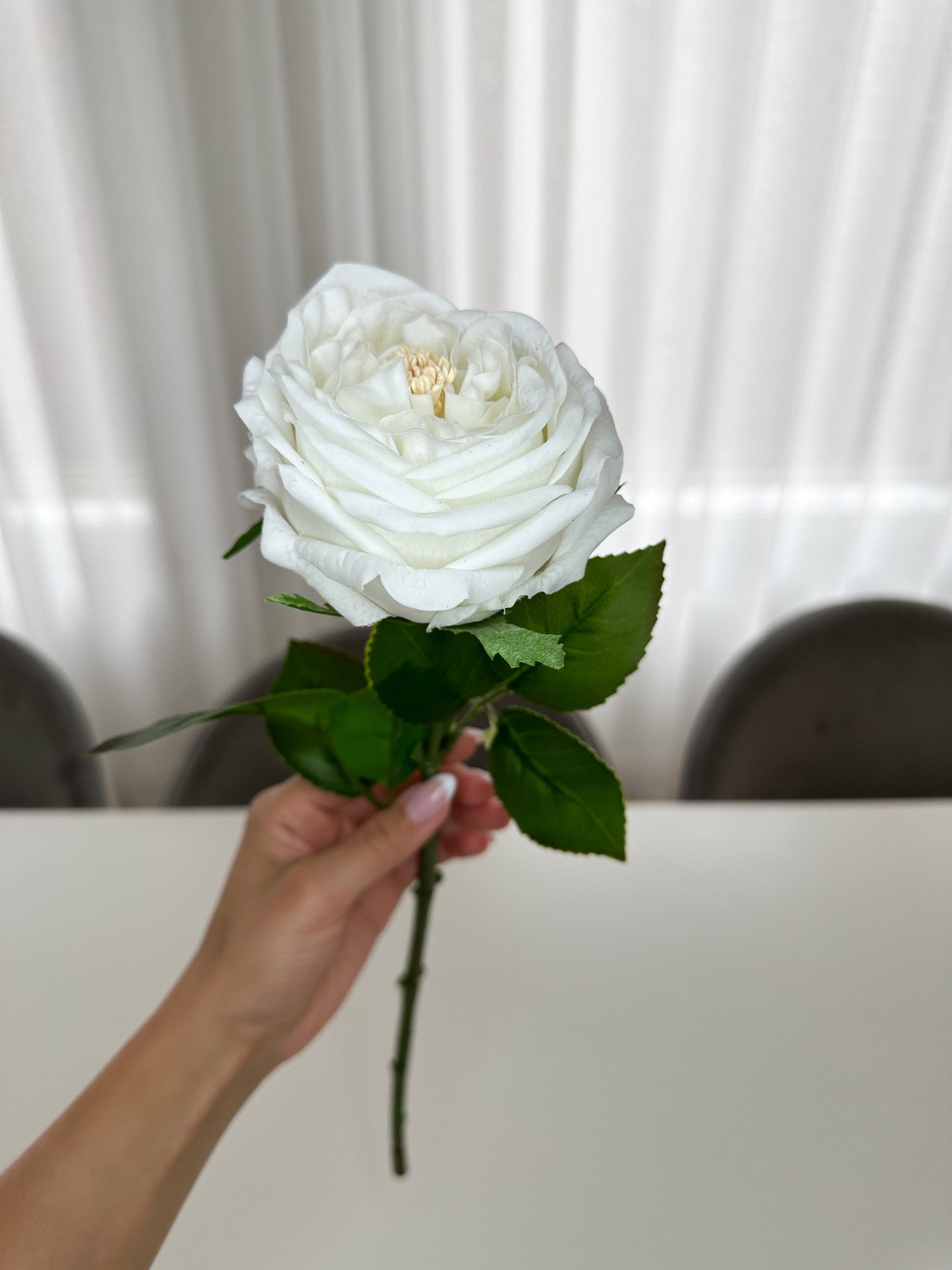 White Real Touch Peony Stem held by a hand